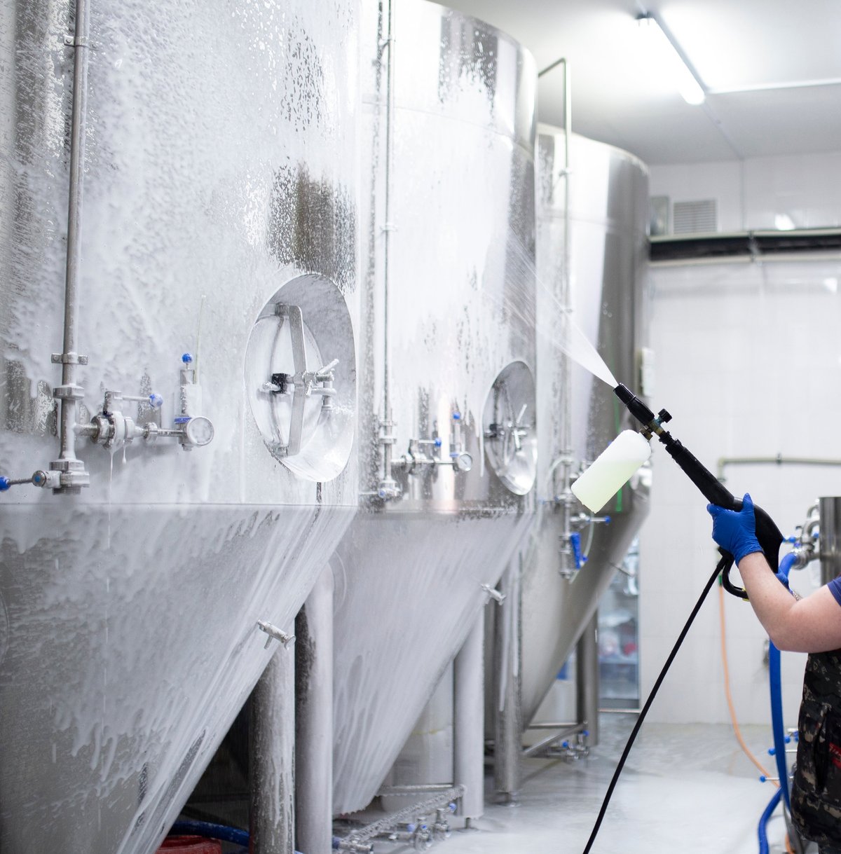 Aplicación de espuma con hidrolavadora de alta presión para limpieza de equipo industrial en fábrica