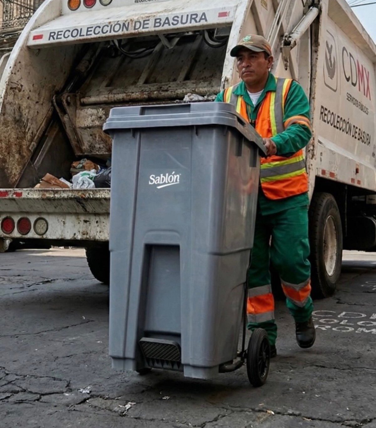 Trabajador de recolección de basura con equipo de seguridad cargando un contenedor Sablón en un camión marcado Recolección de Basura