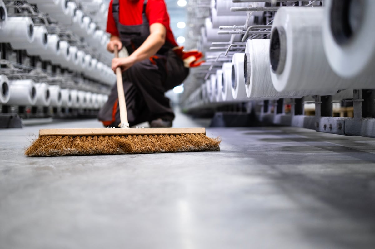 Operario realizando limpieza de piso industrial dentro de una planta de producción